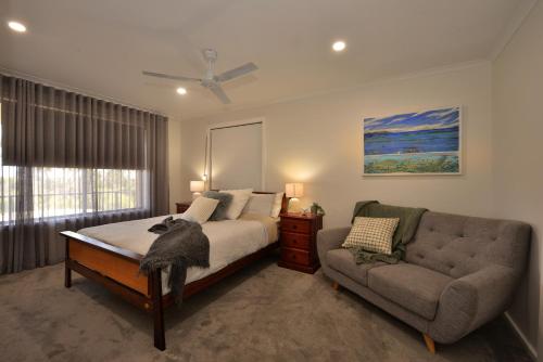 金斯科特Jacks Kangaroo Island的一间卧室配有一张床、一张沙发和一个窗口