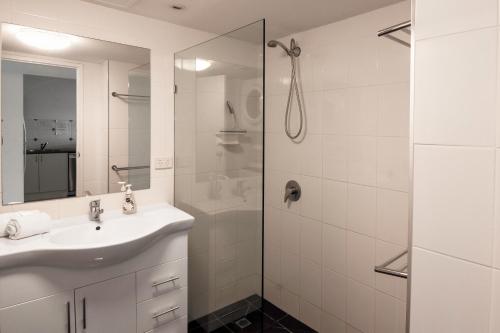 黄金海岸基拉戈假日公寓酒店的白色的浴室设有水槽和淋浴。