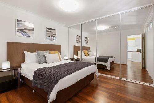 珀斯Swan River Applecross Heathcote Park 1BR Villa的一间卧室配有一张大床和镜子