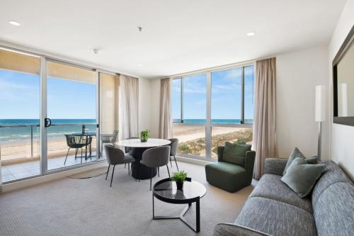 格莱内尔格Belle Escapes - Beachfront Balcony Glenelg的客厅配有沙发和桌子
