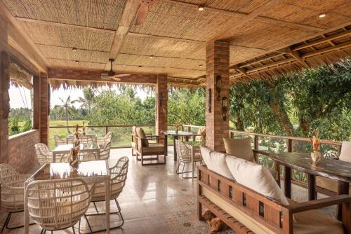 卢纳将军城The Hillside Resort Siargao的一个带桌椅的户外庭院和木制天花板