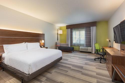 莫雷诺谷Holiday Inn Express & Suites - Moreno Valley - Riverside, an IHG Hotel的配有一张床和一张书桌的酒店客房