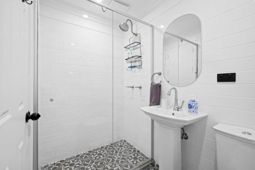 斯普林伍德Mapleton Park Cottage的带淋浴和盥洗盆的白色浴室