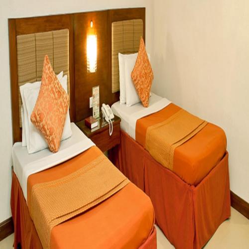 奥萨米斯皇家花园酒店的橙色和白色的酒店客房内的两张床