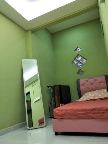 丹那美拉Nik Homestay的卧室配有镜子,毗邻一张床和镜子