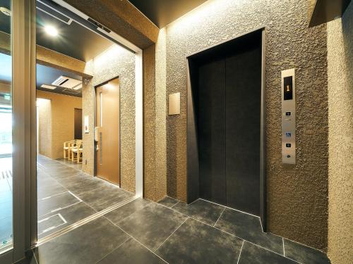福冈Rakuten STAY Hakata Gion 401 Superior Room的大楼内带门的走廊