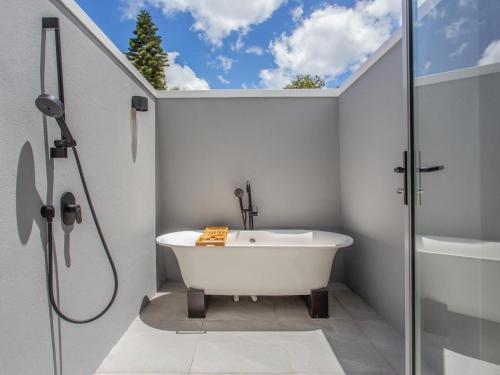 豪特湾Bluemari's Retreat的设有带浴缸和淋浴的浴室。