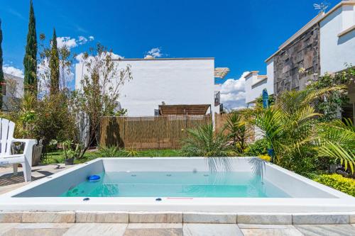 莱昂Lujosa casa: alberca terapéutica 3x2m, chimenea, cocina profesional的房屋后院的游泳池