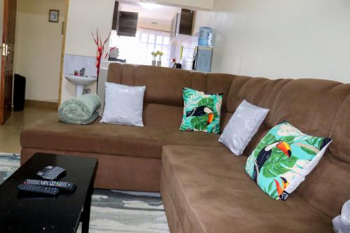 埃尔多雷特Fully Furnished 2BR Eclectic Homestay near UOE的客厅里配有带枕头的棕色沙发