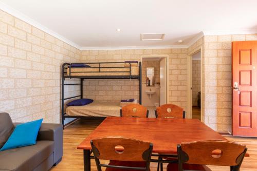 卡尔巴里卡尔巴里铎假日公园酒店的客房设有桌子、沙发和双层床。