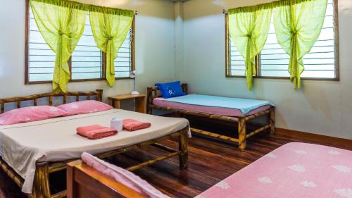 爱妮岛High Chaparral Cottages的客房设有两张床、一张长凳和窗户。