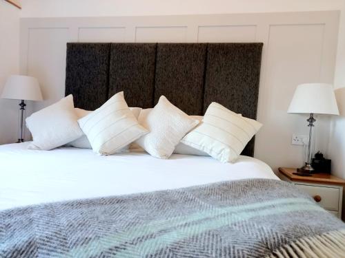 比尔斯韦尔斯Irfon Cottage的卧室配有白色大床和白色枕头