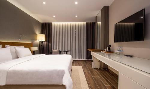 阿塔库姆Elite World Comfy Samsun Atakum的一间酒店客房,配有一张白色的床和一张书桌