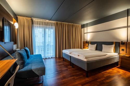 哥本哈根韦斯特布罗康福酒店 的酒店客房,配有床和蓝色的沙发