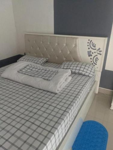 吉塞尼Ignite guest house的一张带灰色白色床架和蓝色地毯的床