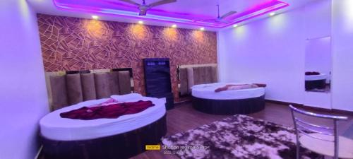 新德里Hotel The Avtar- Near Delhi Railway Station的紫色灯房内的两张床