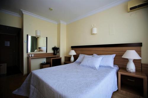 安塔利亚拉拉酒店 的一间卧室配有一张床、两盏灯和一面镜子