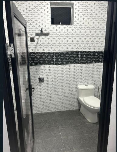 亚娄Dya@Nas Homestay Arau的浴室设有卫生间,铺有黑白瓷砖。