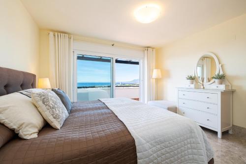 马贝拉Dúplex de Lujo Marbella Golf的一间卧室设有一张大床和大窗户