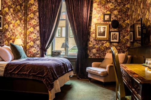 哥德堡皮加勒酒店的卧室配有床、椅子和窗户。