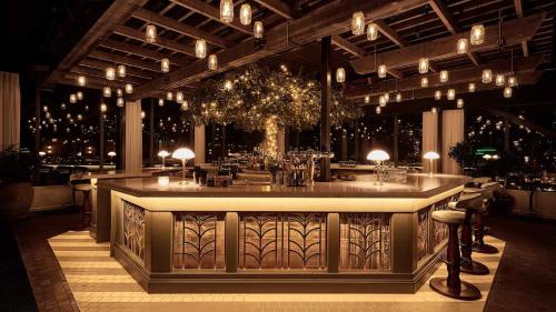 韦斯特罗斯Steam Hotel的一间设有酒吧的餐厅,位于一间灯光明亮的房间内