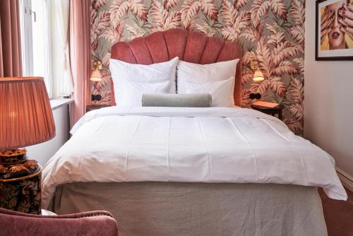 马尔默MJ酒店的一间卧室配有一张白色大床和红色床头板