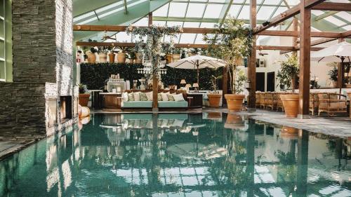 法尔肯贝里法尔肯伯格斯坦拜德酒店的一座带桌子和遮阳伞的建筑中的游泳池