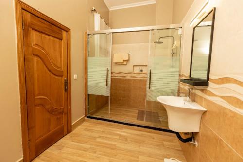 基加利INGANZO BOUTIQUE HOTEL的一间带玻璃淋浴和水槽的浴室