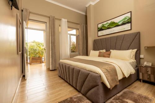 基加利INGANZO BOUTIQUE HOTEL的一间卧室设有一张大床和一个大窗户