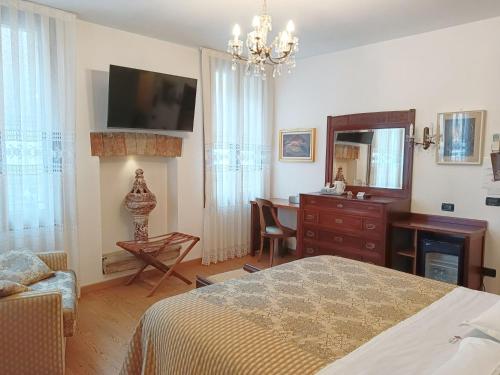 特雷维索Hotel Relais San Nicolò的一间卧室配有一张床、一张书桌和一面镜子