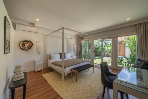 坎古Villa Kelapa Putih - Spacious 4-bedroom Villa with pool PERFECT LOCATION的一间卧室配有一张天蓬床和一张书桌