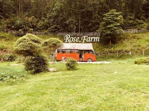 奠边府市Eco Rose Homestay的一辆橘子巴士停在草地上
