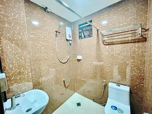 马尼拉OYO 1045 Rayjan Apartelle的带淋浴、卫生间和盥洗盆的浴室