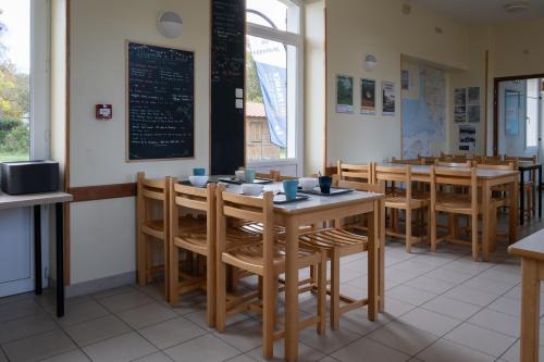 GenêtsAuberge de Jeunesse HI Genêts的用餐室配有桌椅和黑板
