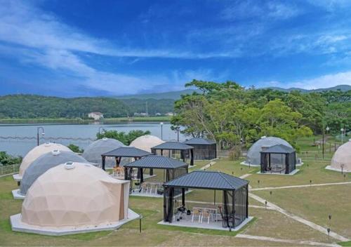 出云市Glamping Base IZUMO "Lakeside Hot Spring Hotel Kun - Vacation STAY 42014v的一群帐篷位于湖边的田野