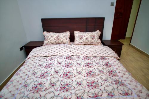 KiraATA Luxe Apartments的一间卧室配有一张带被子和枕头的床