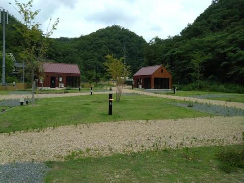 ShōbaraAyu no Sato Park Campsite - Vacation STAY 42154v的绿色的田野,有两栋建筑