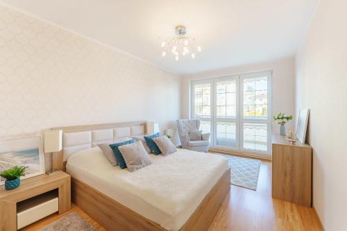 格里兹鲍AM Seaside - Apartament的白色卧室配有一张床和一个吊灯