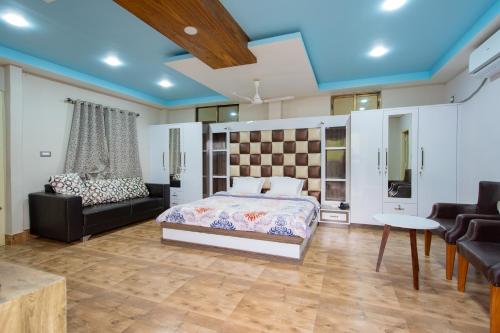 因帕尔RaDiant Club & Resort的一间卧室配有一张床和一张沙发