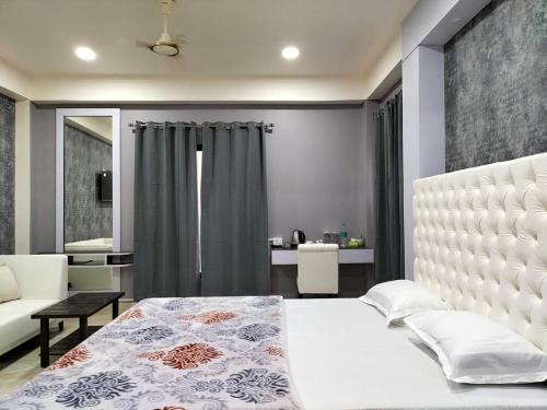 因帕尔RaDiant Club & Resort的一间带白色床的卧室和一间客厅