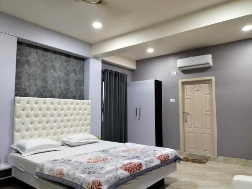 因帕尔RaDiant Club & Resort的一间卧室设有一张大床和一扇门
