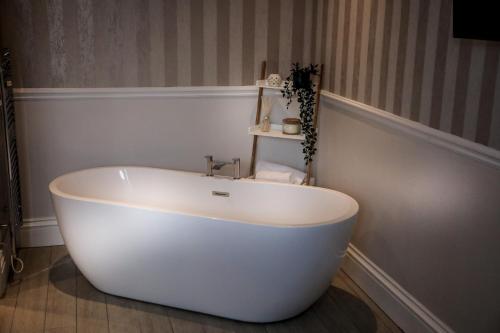 卡莱尔坎布里亚公园酒店的浴室内设有一个白色浴缸
