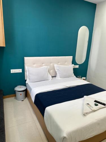 苏拉特Hotel sky palace adajan的一间卧室设有两张床和蓝色的墙壁