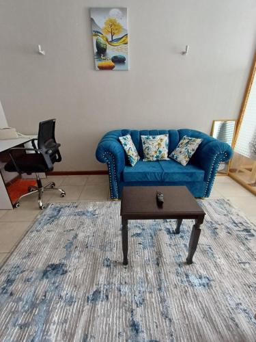内罗毕LaMeg Homestay的客厅配有蓝色的沙发和桌子