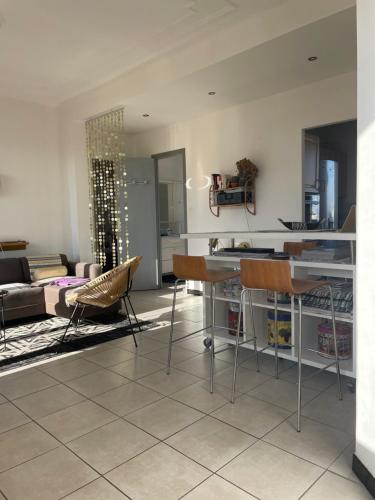 马赛Appart 60 m2 avec terrasse 35m2 séjour sud et 2 vraies chambres gare Saint-Charles的厨房以及带桌椅的起居室。