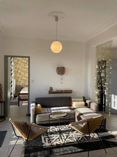 马赛Appart 60 m2 avec terrasse 35m2 séjour sud et 2 vraies chambres gare Saint-Charles的客厅配有沙发和桌椅