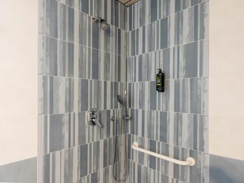 巴里B&B HOTEL Bari Rondò的浴室铺有蓝色和白色瓷砖,配有淋浴