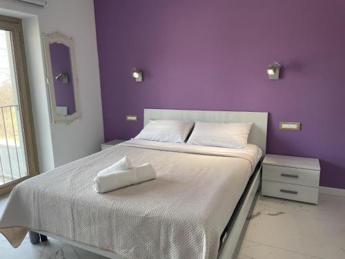 蒙多维Le Ghie的卧室配有白色床和紫色墙壁
