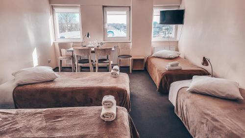 帕内韦日斯佩瓦匝酒店的带三张床的房间和带桌子的用餐室