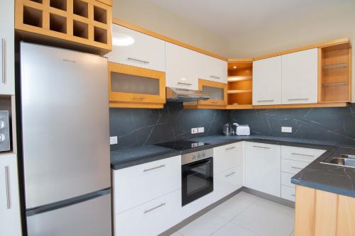 斯利马Venus Apartment的厨房配有白色橱柜和冰箱。